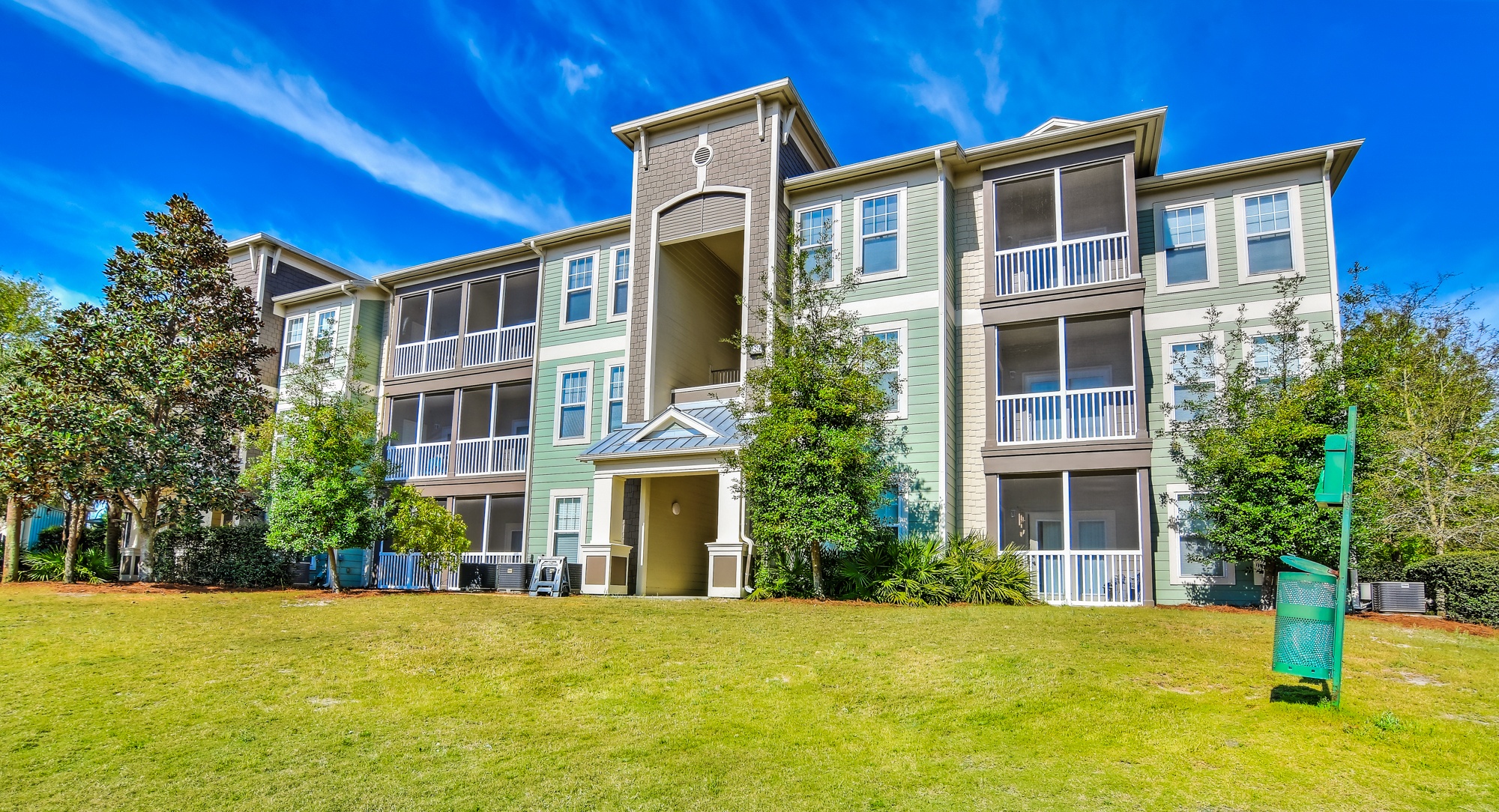 A large apartment complex with a green lawn in front.